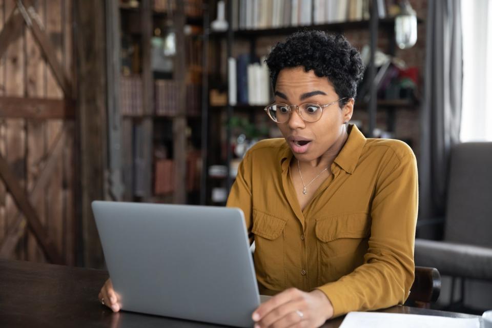 A person in front of a laptop seems surprised.