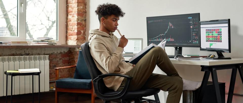 Investor sitting at computer desk. 