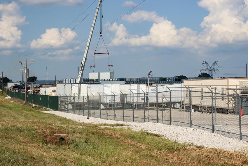 Trucks are parked alongside containers of computers owned by Marathon Digital at the Bitcoin mine in Granbury, on Tuesday, June 11, 2024.