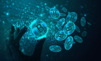 Bitcoins in a futuristic room made from binary code and a hand holding one of them. (Used clipping mask)